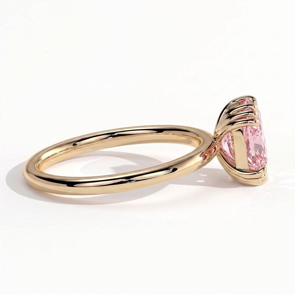 Fancy Vivid Pink elongated cushion lab-grown diamond solitaire engagement ring with triple claw prongs in 14K (585) yellow gold, detail view of the triple claws 