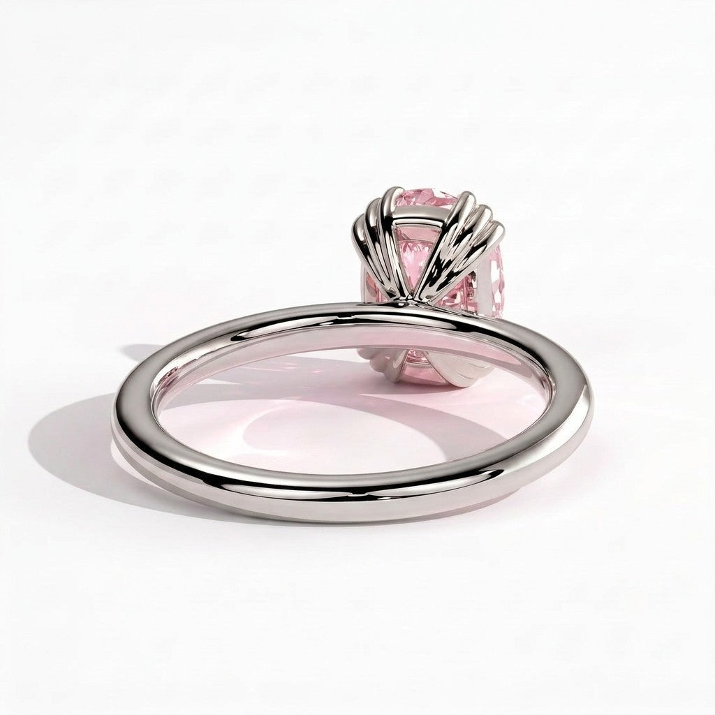 Fancy Vivid Pink elongated cushion lab-grown diamond solitaire engagement ring with triple claw prongs in 950 platinum, detail view of the triple claws 