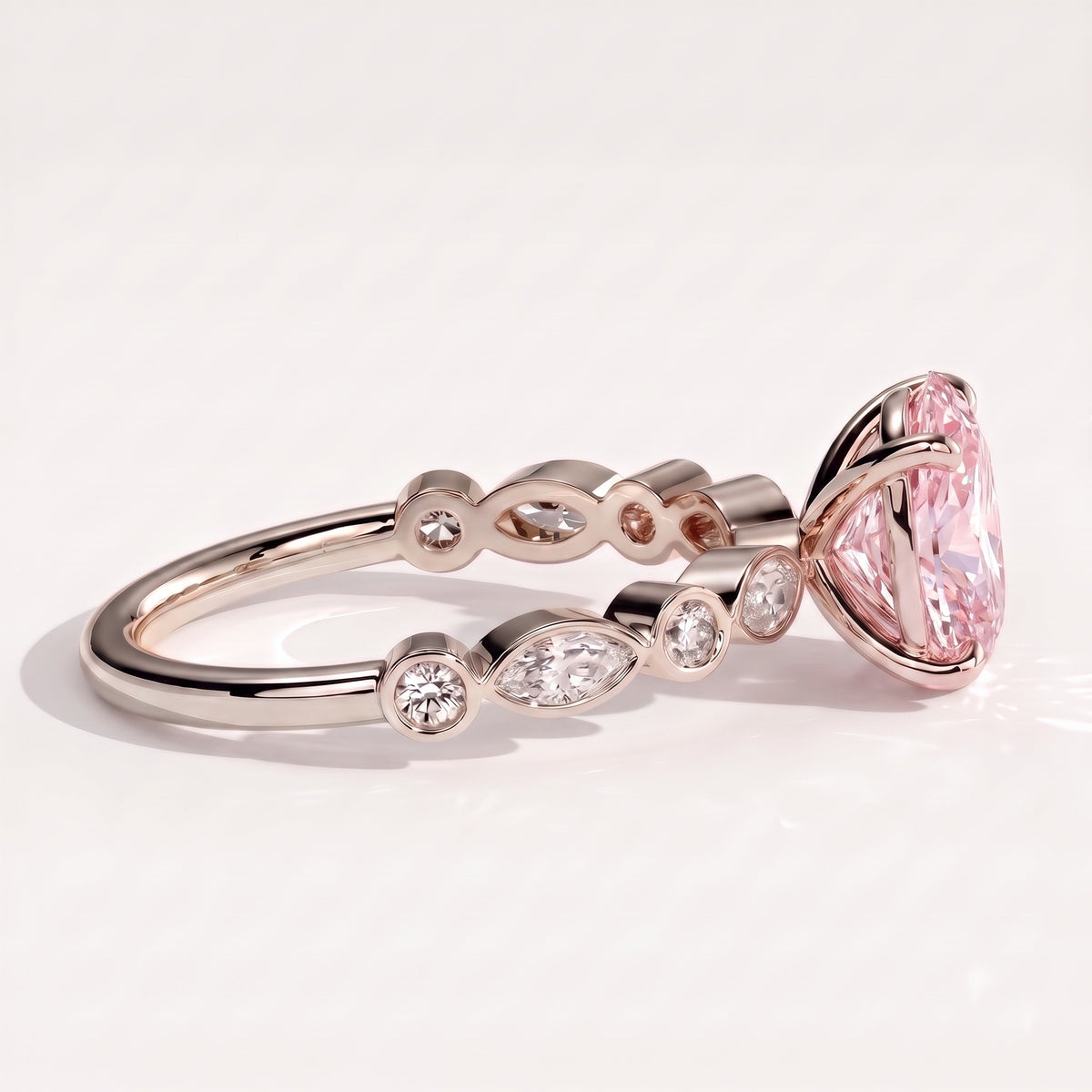 Fancy Vivid Pink oval lab-grown diamond engagement ring with bezel-set pear and round shoulder accents in 14K (585) white gold, detail view of the bezel-set shoulder accents 
