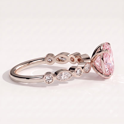 Fancy Vivid Pink oval lab-grown diamond engagement ring with bezel-set pear and round shoulder accents in 18K (750) white gold, detail view of the bezel-set shoulder accents 