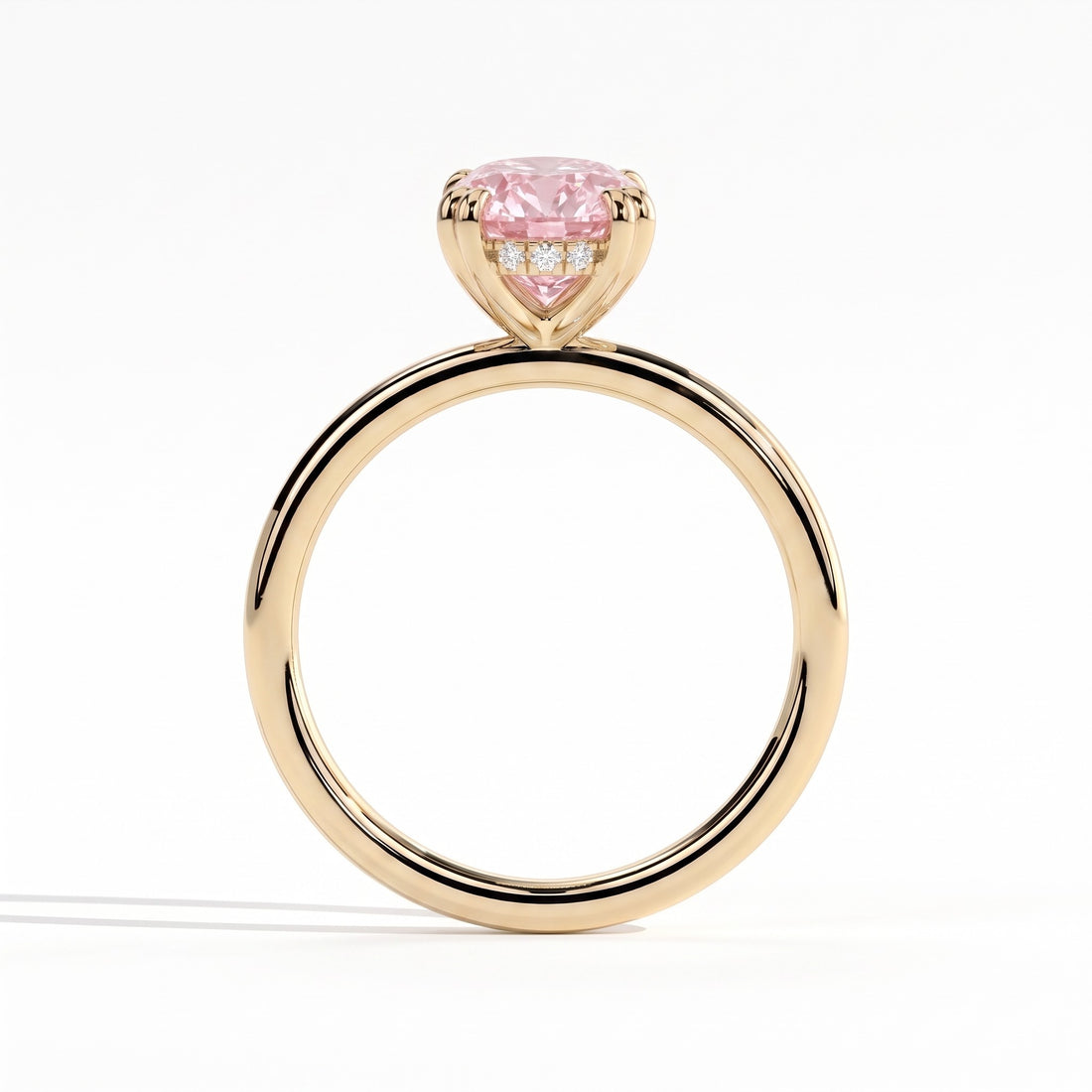 Fancy Vivid Pink oval lab-grown diamond double claw engagement ring with hidden halo in 14K (585) yellow gold, side profile showing the hidden halo 