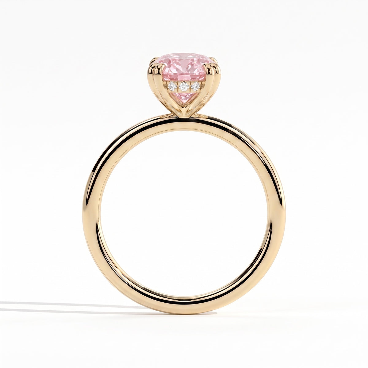 Fancy Vivid Pink oval lab-grown diamond double claw engagement ring with hidden halo in 18K (750) yellow gold, side profile showing the hidden halo 