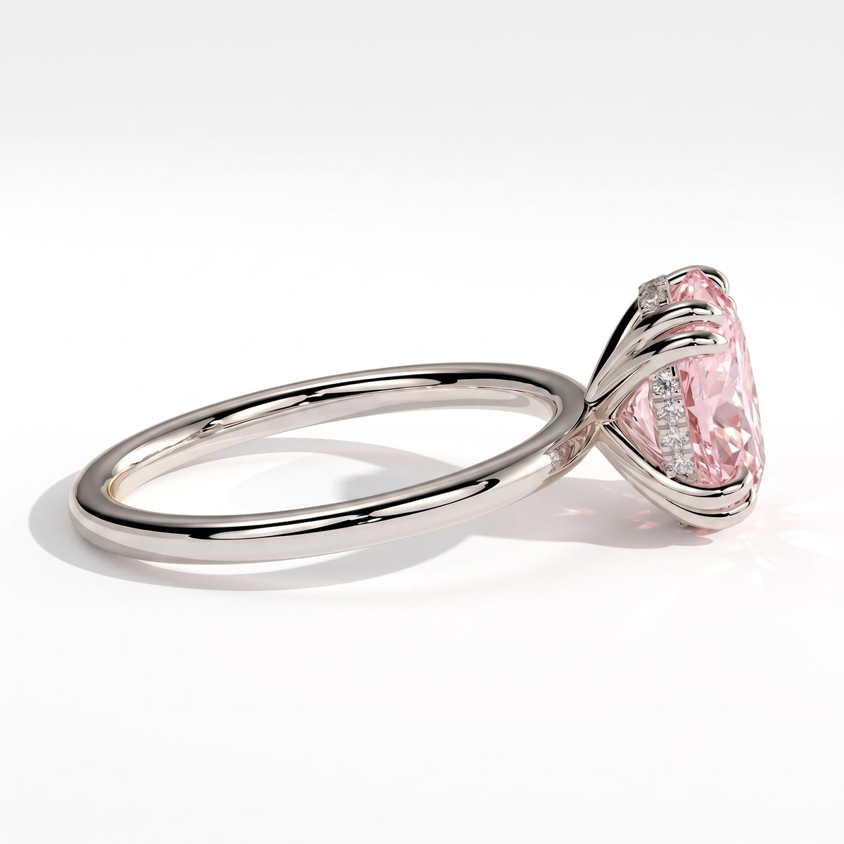Fancy Vivid Pink oval lab-grown diamond double claw engagement ring with hidden halo in 950 platinum, detail view of the double claws 