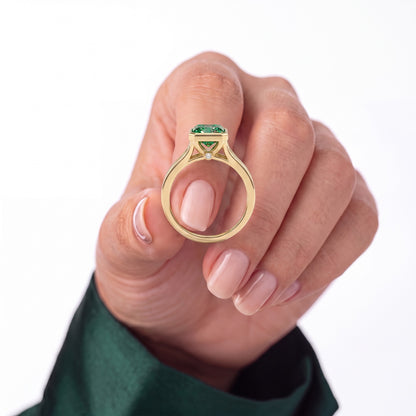 Fancy Vivid Green radiant lab-grown diamond bezel ring in 18K (750) rose gold, held in hand showing ring profile 