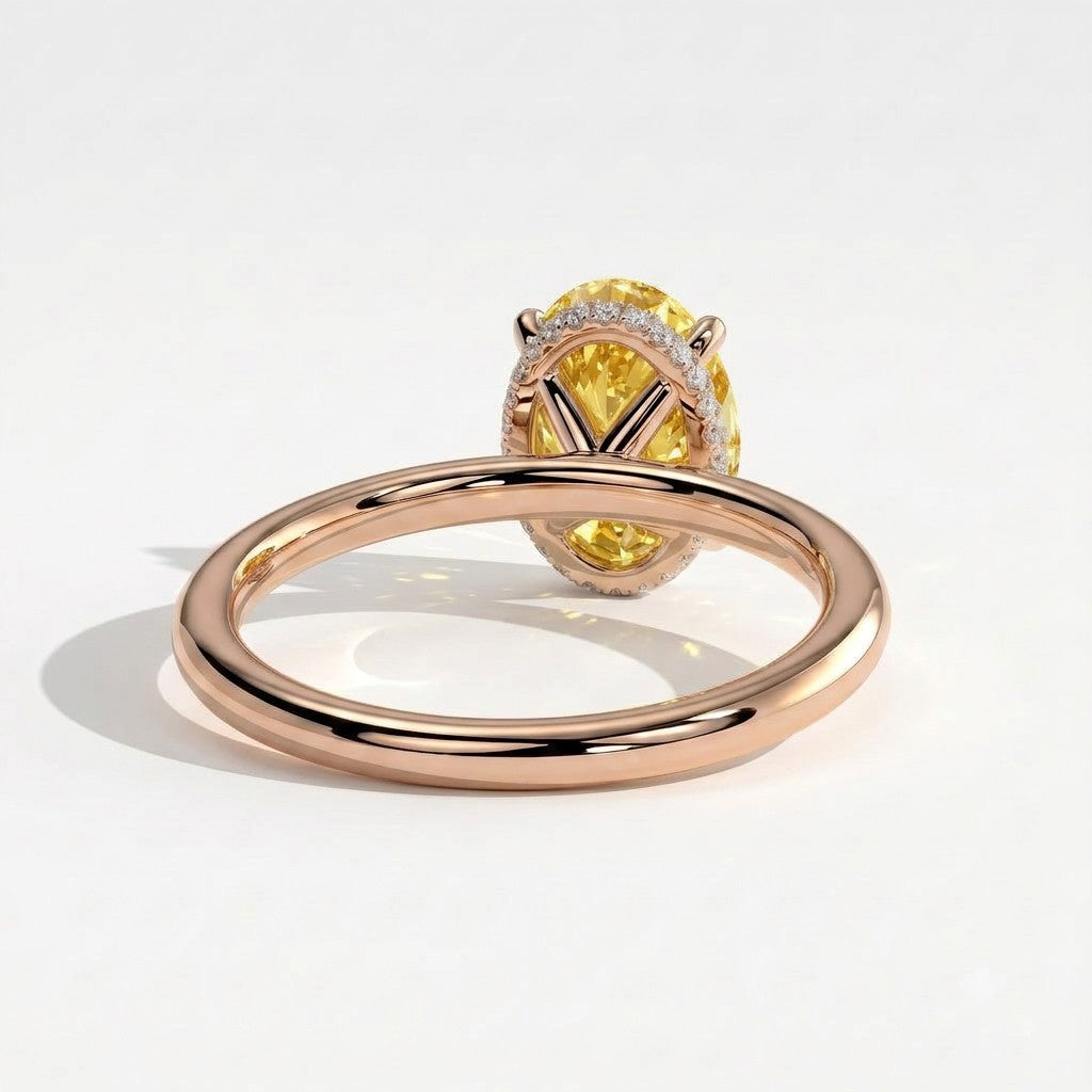 Fancy Vivid Yellow oval lab-grown diamond engagement ring with wrap-around hidden halo in 18K (750) rose gold, on white background 