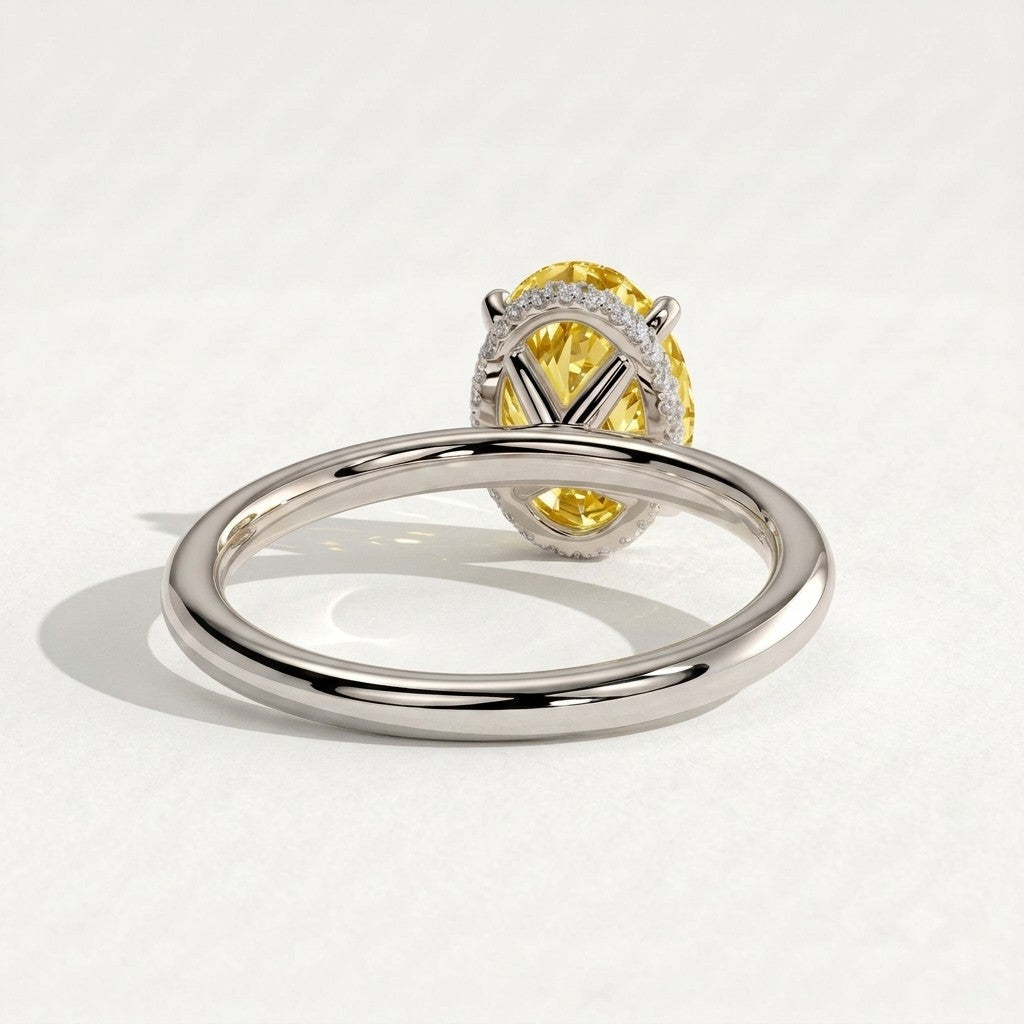 Fancy Vivid Yellow oval lab-grown diamond engagement ring with wrap-around hidden halo in 950 platinum, on white background 