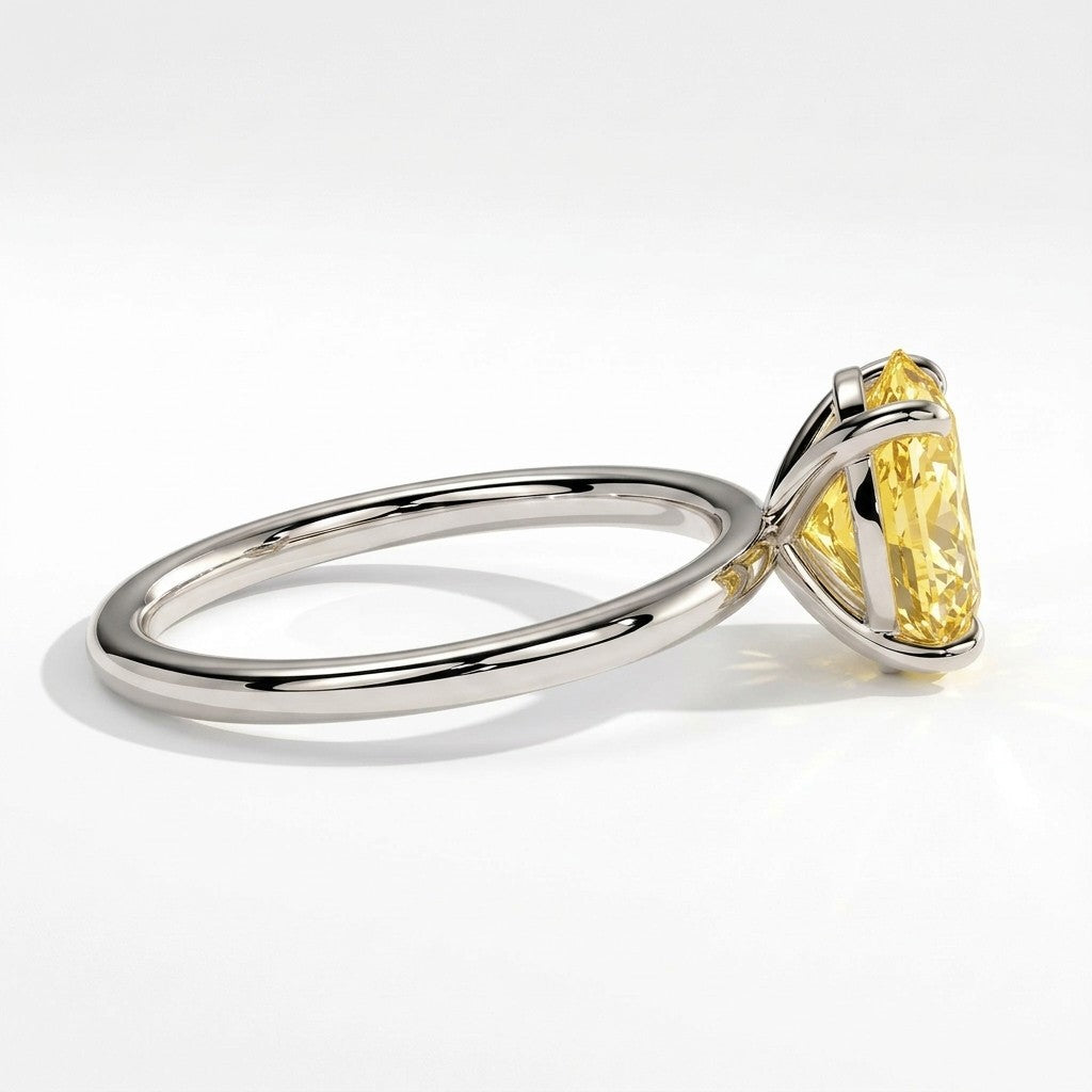 Fancy Vivid Yellow oval lab-grown diamond solitaire engagement ring in 950 platinum, detail view of the four-claw setting 